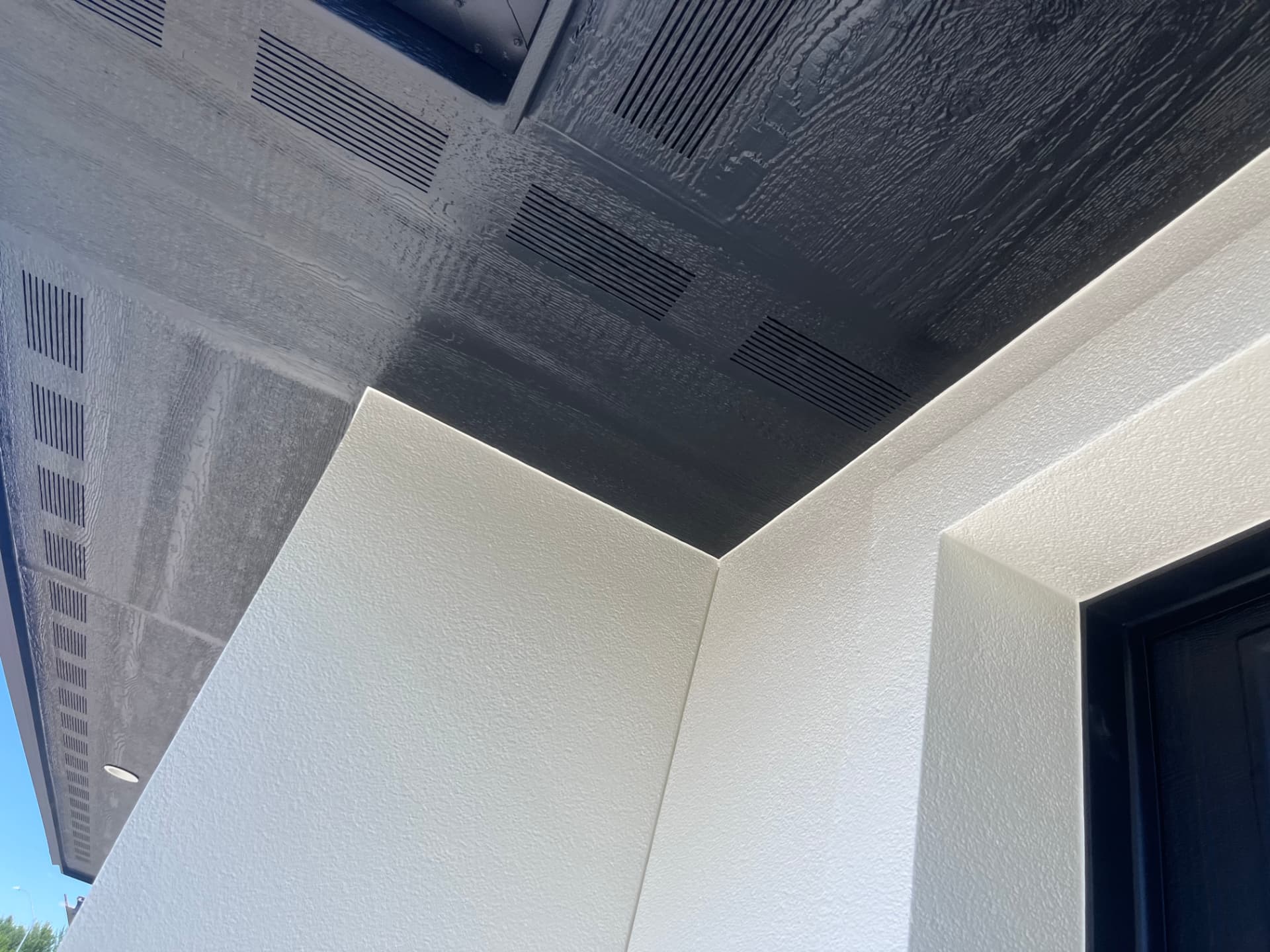 Close-up of a painted exterior corner, soffit, and vents with clean lines